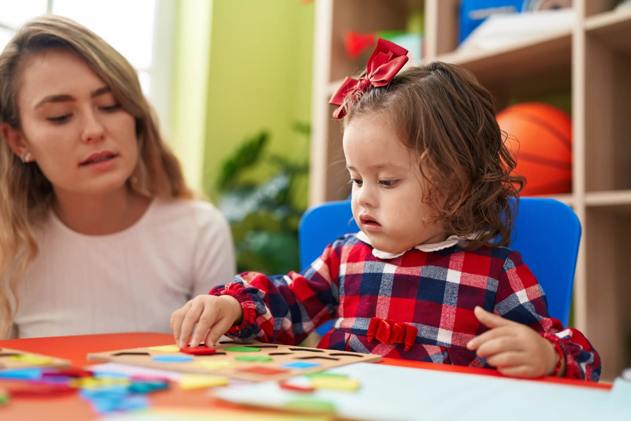 Child care provider helping school-age child with learning activities